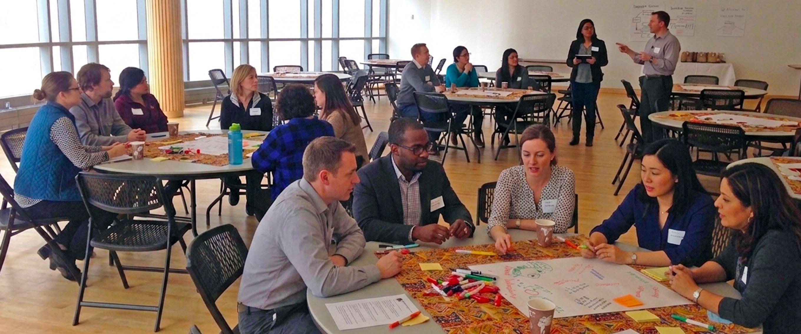 Group of advisors sitting at tables doing an activity.